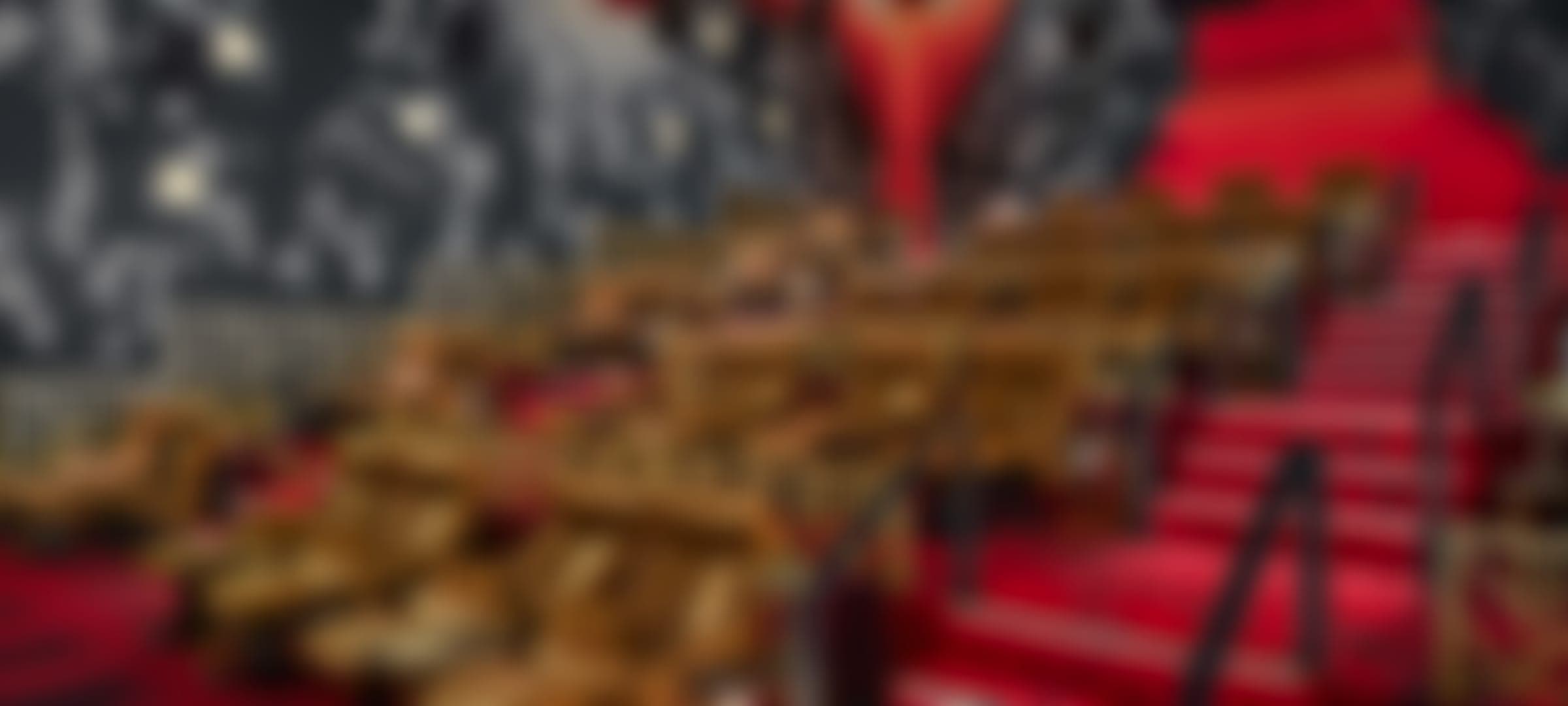 Leather recliners and red carpet in a premium cinema, softly blurred